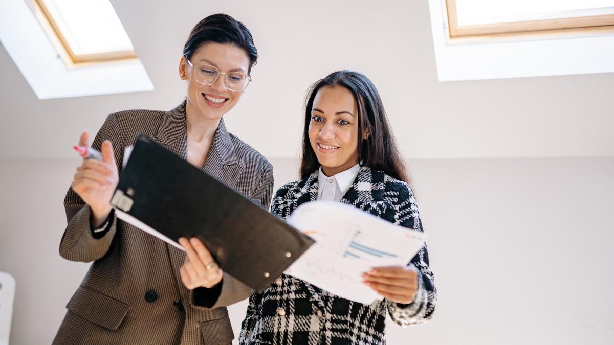 Two HR managers reviewing a leave approval workflow report together
