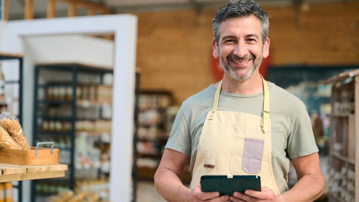 A small business owner using a tablet in his shop